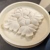 1 Cementicious coating on a round medallion