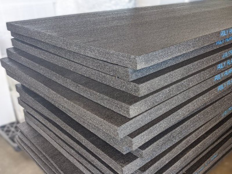 Black polyethlyene PE foam sheets that are 4' x 9' stacked in a pile