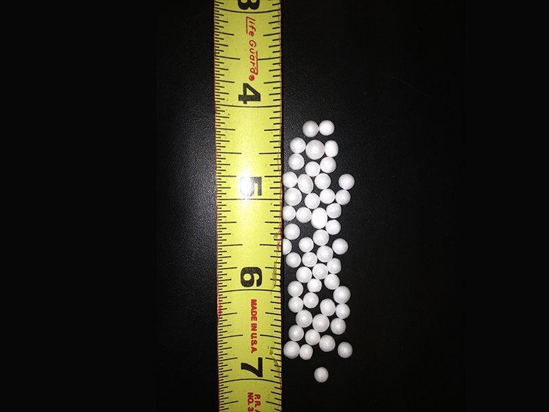 Expanded polystyrene beads next to a measuring tape